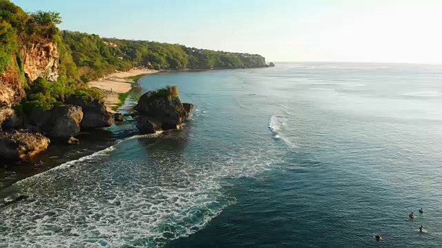 鸟瞰图的海岸线，海洋和冲浪者等待海浪视频素材