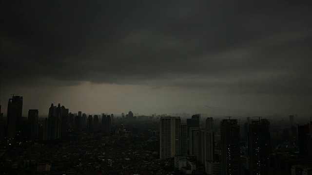 强烈的暴风雨乌云布满了雅加达的天空，遮蔽了印尼城市的所有阳光视频素材