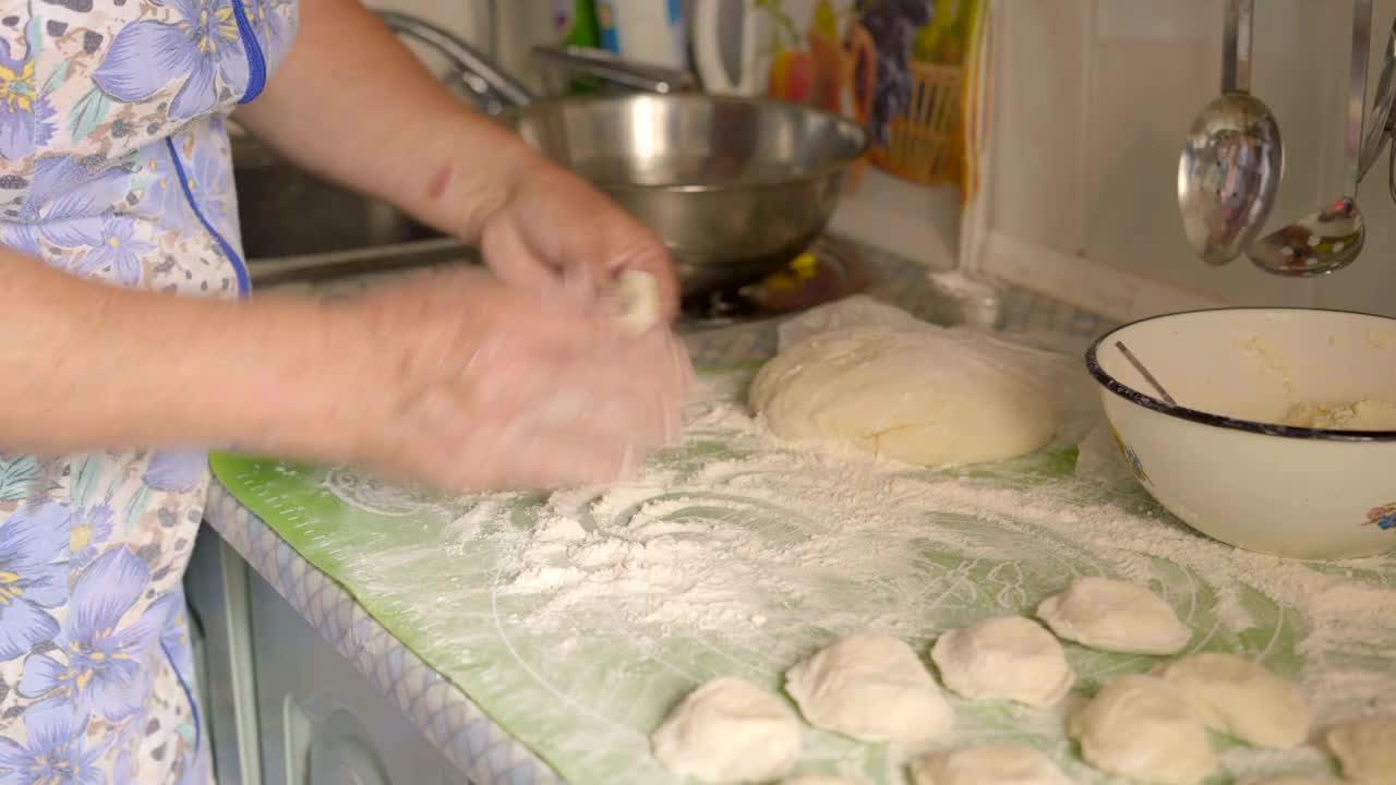 特写，老妇人用白软干酪填充面团做馅饼视频下载