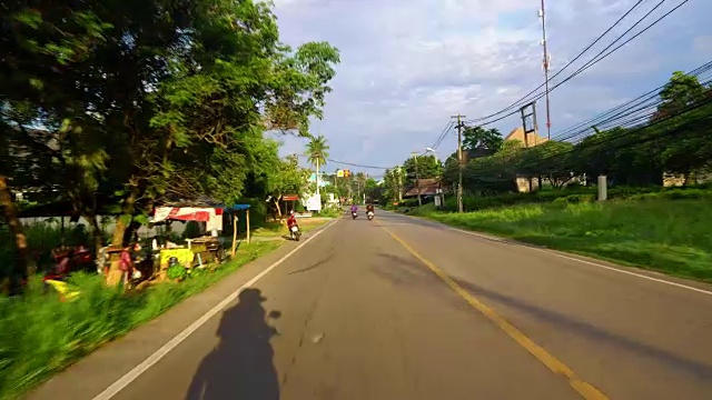 乘坐摩托车或汽车在亚洲公路上旅行。热带国家，沿路有棕榈树视频素材