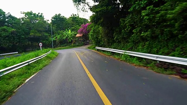 在亚洲热带地区的空旷道路上行驶，经过棕榈树视频素材