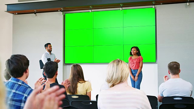 女学生在屏幕前给高中班级做演讲视频素材