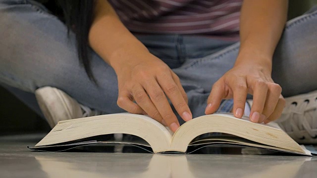 年轻的亚洲学生女孩在大学图书馆看书，教育和学校的概念视频素材