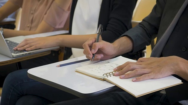 年轻的亚洲人在笔记本上写作，在大学图书馆或教室里做研究，学习教育和学校理念视频素材