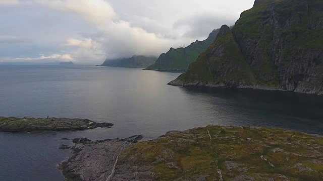 在午夜太阳，挪威罗浮敦的陡峭山峰上移动的云层鸟瞰图视频素材