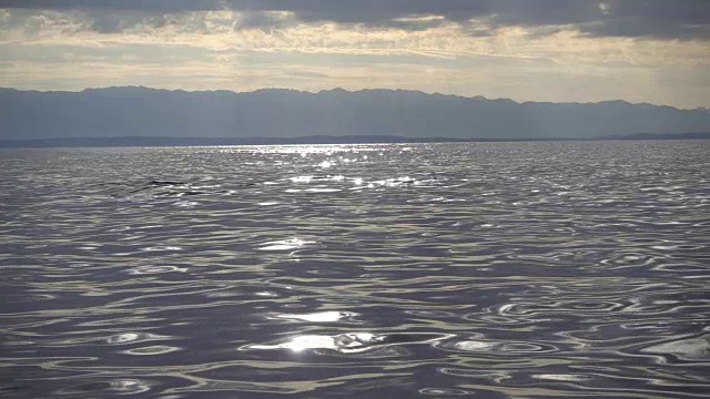 海上日出。慢镜头中的波浪，地平线上的阳光视频素材