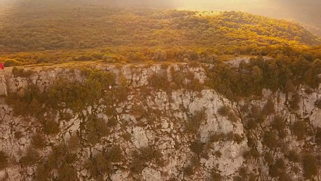 无人机飞行在岩石山悬崖上的4k超高清镜头在夏季日落高视频素材