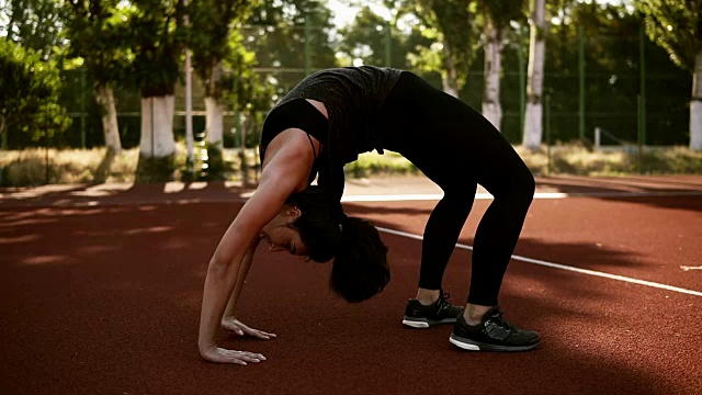 运动女性做桥牌瑜伽练习从坐位回到坐位。黑发白种女人锻炼肌肉，锻炼柔韧性。室外体育场视频素材