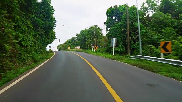 在柏油路上开车，可以看到这个热带岛屿的美丽景色视频素材