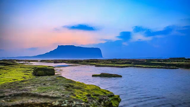 韩国济州岛的Seongsanilchulbong山(著名的日出地点)和海滩上的日落视频素材