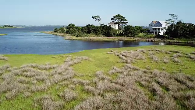 在北卡罗来纳州的翡翠岛，一架无人机在海岸内水道的沼泽草上空飞行视频素材