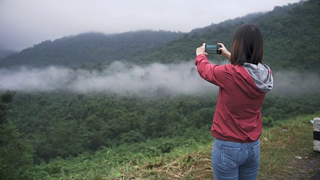 女人用智能手机拍摄美丽的风景视频素材