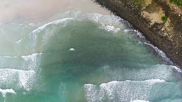 无人机拍摄的海浪到达海岸的画面。海滩上无人机俯视图。视频素材