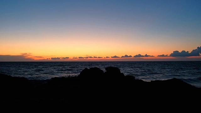 海上日落。平静的田园诗般的景色，金色的日落在海面上，海浪慢慢地溅起水花视频素材