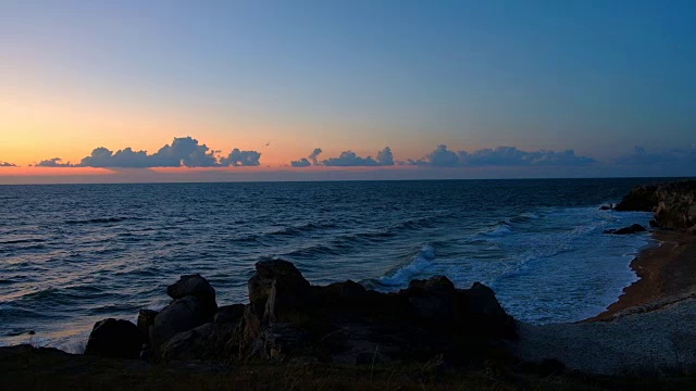 海浪轻轻地冲到两块岩石之间的海滩上视频素材