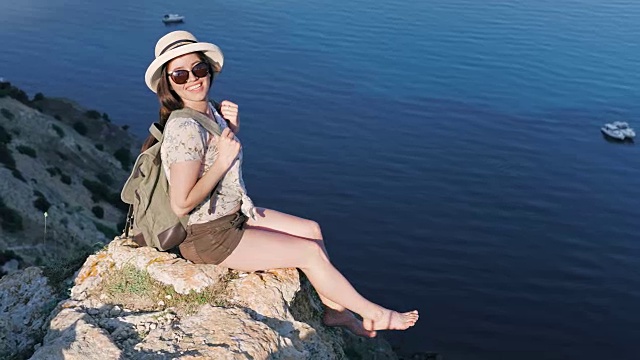 高角度好玩的背包赤脚女人在帽子享受海湾和海景视频素材