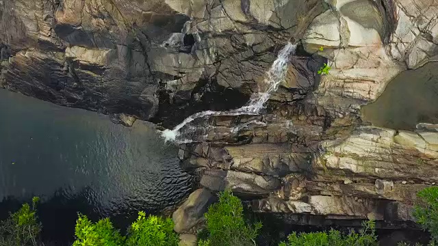 山涧瀑布和河流在丛林鸟瞰图中流动。无人机飞越岩石瀑布和山区河流在雨林。野生自然景观视频素材