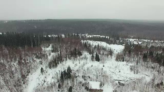 在多云的天气和降雪中飞过冬天的森林景观。视频素材