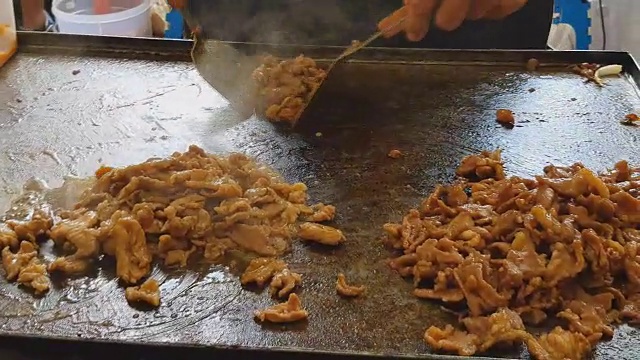 烤肉，烤火猪肉在平底锅上在黑暗的背景，烧烤烧烤火焰火，街头小吃视频素材