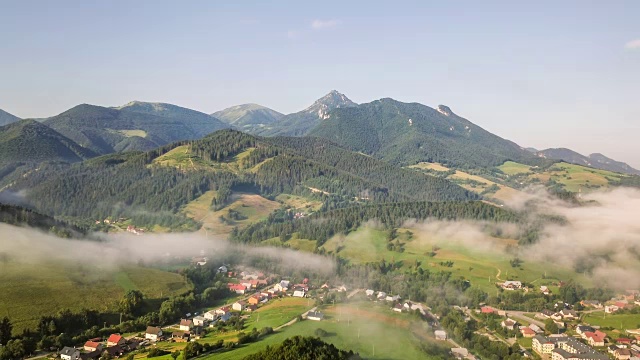 乡村碧绿的山峦中，雾蒙蒙的早晨。空中时间流逝视频素材