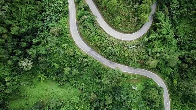 鸟瞰图蜿蜒的道路在森林和汽车驾驶，安全驾驶的概念视频素材