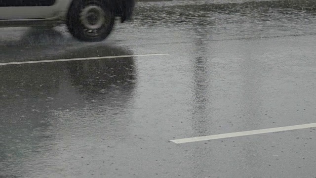 一辆汽车在洪水中被溅到。雨天在城市道路上行驶的汽车。缓慢的运动。视频素材