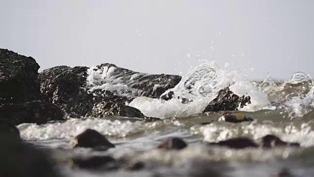 海浪向岩石海滩袭来的慢镜头视频素材