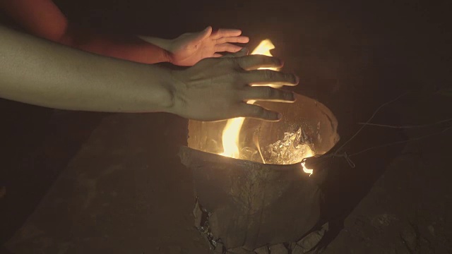 在寒冷的冬夜，坐在篝火前暖手视频下载