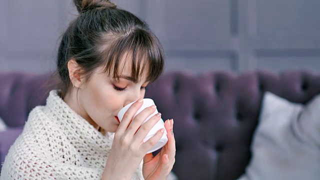 特写肖像浪漫的家庭年轻女子喝热饮杯包裹在格子视频素材