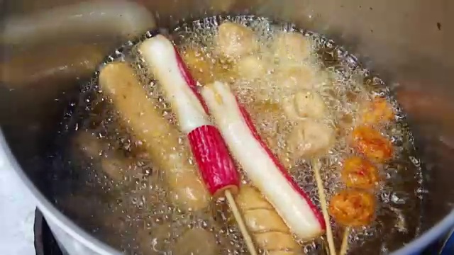 在热油中炸，肉丸，垃圾食品在滚烫的油视频下载