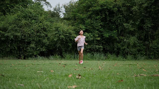 慢镜头，快乐的小女孩在公园里跑步微笑视频素材