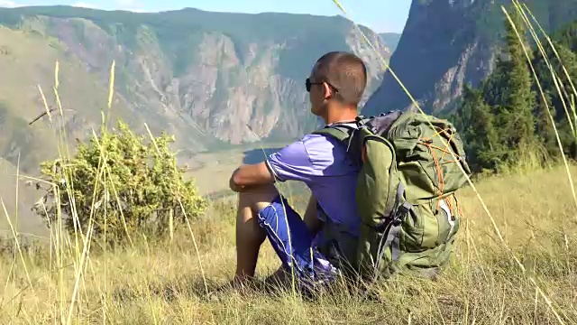 一个背着背包在山里的游客。视频素材