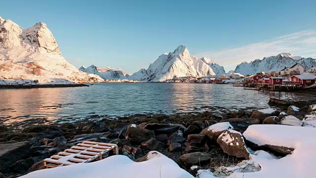 在罗浮敦群岛的海岸线上有蓝天的雪山的斯堪的纳维亚村庄的延时拍摄视频素材