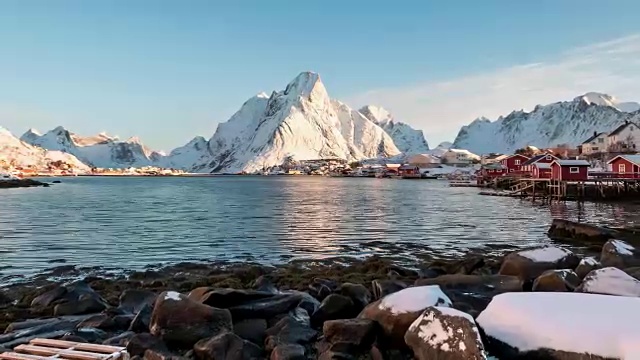 在罗浮敦群岛的海岸线上有蓝天的雪山的斯堪的纳维亚村庄的延时拍摄视频素材