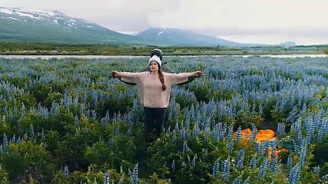 多民族夫妇欣赏盛开的羽扇豆花。张开双臂视频素材