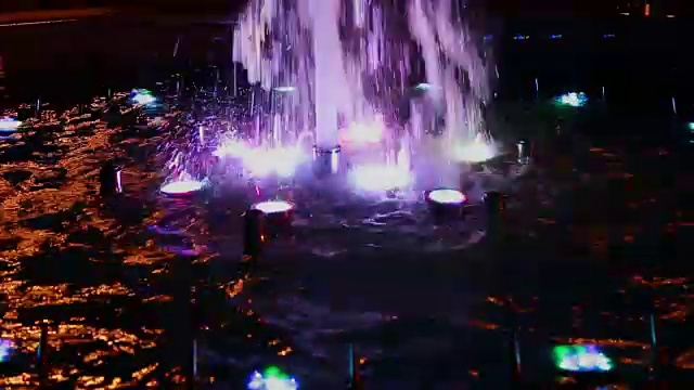 五彩缤纷的音乐喷泉在夜晚，闪烁着不同的色彩视频素材