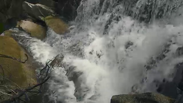 瀑布瀑布般在山上流动。从瀑布中流淌的水在山河中的巨石上视频素材