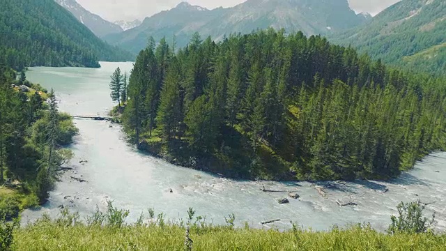 无人机飞过一个海滩与波浪翻滚和大山脉周围的海岸景观与山脉的背景视频素材