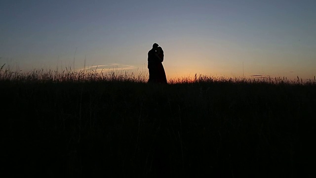 一对相爱的情侣在河边接吻。夕阳光视频素材