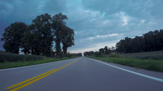 在多云的天空下沿着双巷乡村道路行驶视频素材