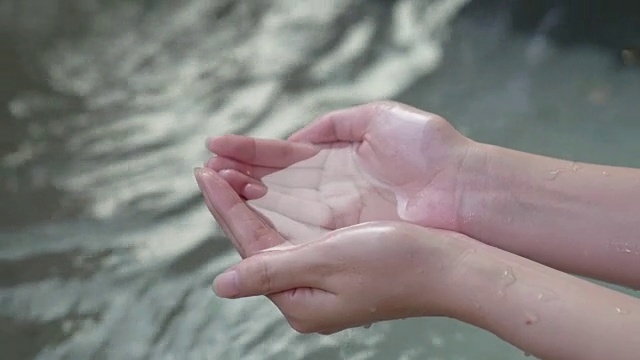 女孩用手舀了一勺清水视频素材