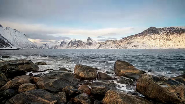 海景波与北极海岸线上的雪山撞击岩石的延时视频素材