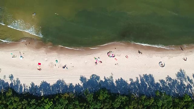 鸟瞰图与日光浴的沙滩和海浪。视频素材