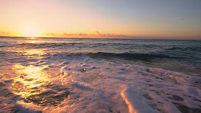 海滩上的热带日出。海浪冲刷着沙滩视频素材