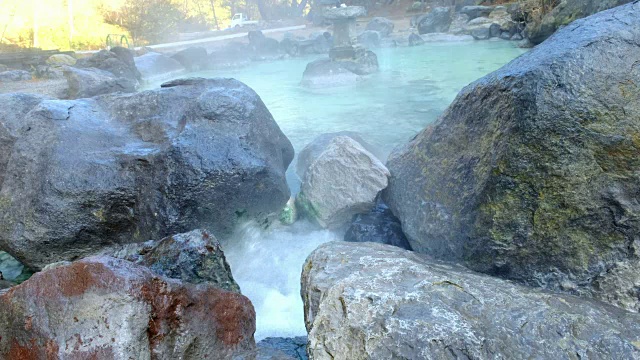 在日本草松温泉，温泉源的水流动通过的方式和岩石在一个温暖的溪流下山谷，日本视频素材