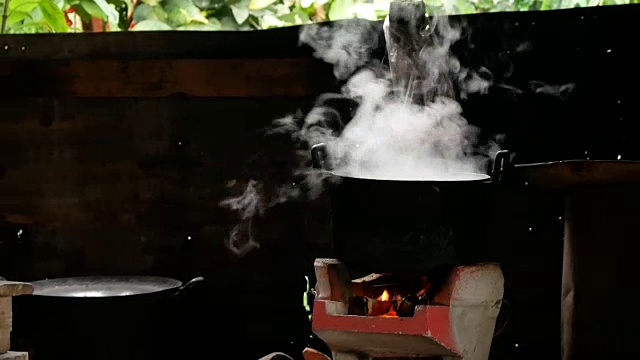 锅上烧黑了，锅上有蒸汽，泥炉和柴火视频素材