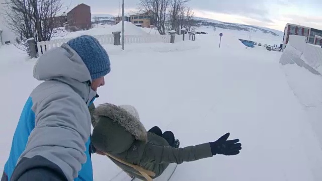 POV夫妇有乐趣踢滑雪橇通过城镇视频素材