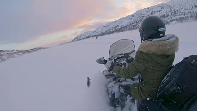 SLO MO POV人们骑着雪地摩托穿过雪地视频素材