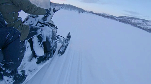 SLO MO POV夫妇骑着雪地摩托穿越挪威的雪地视频素材