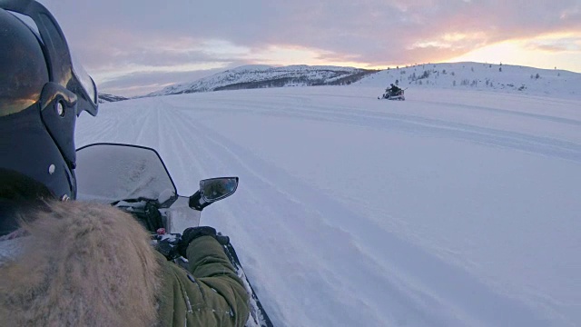 SLO MO POV人们开着雪地摩托在雪地里赛跑视频素材